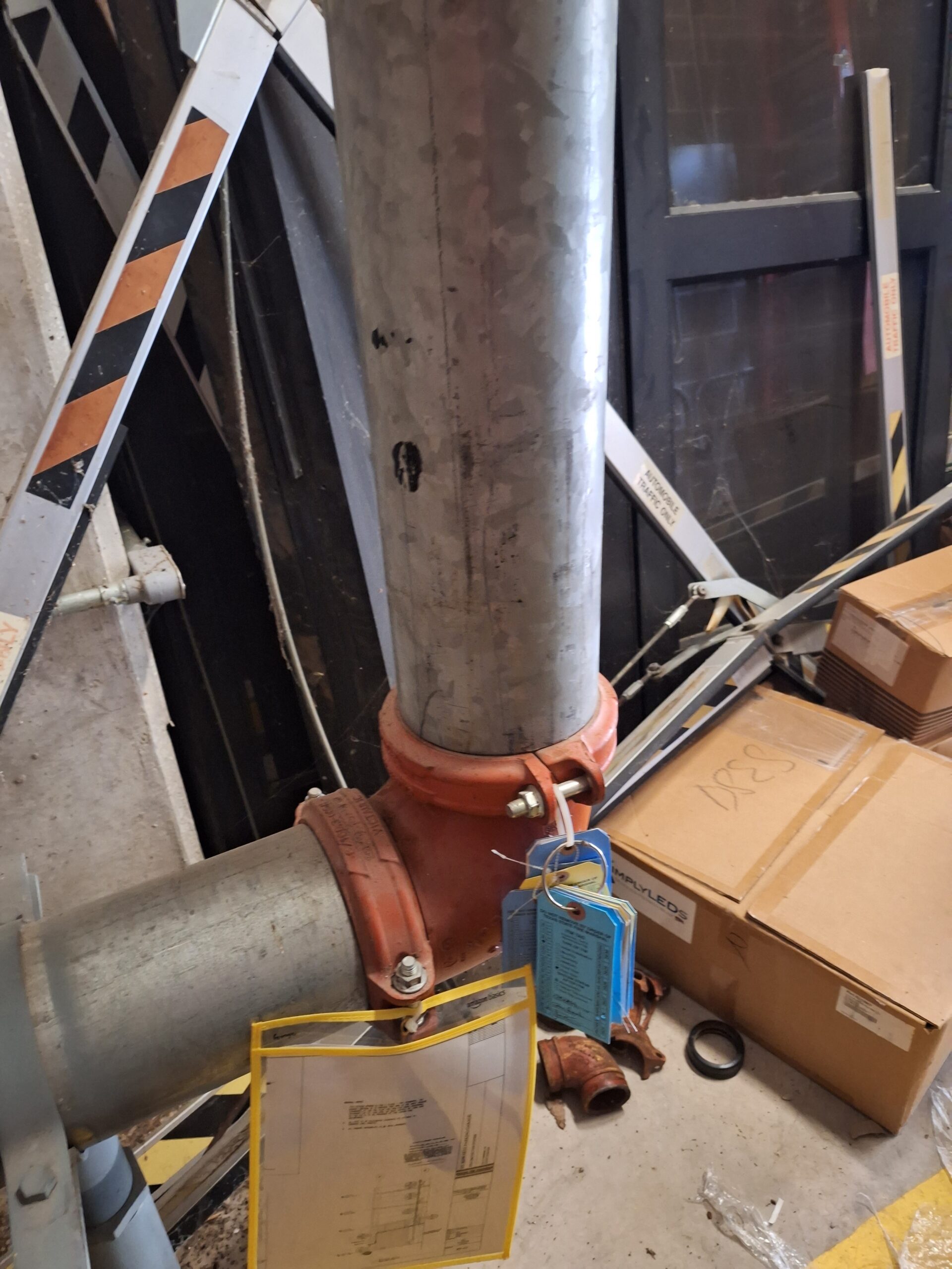 A fire inspector checking a commercial sprinkler pipe for MIC corrosion and sludge buildup.